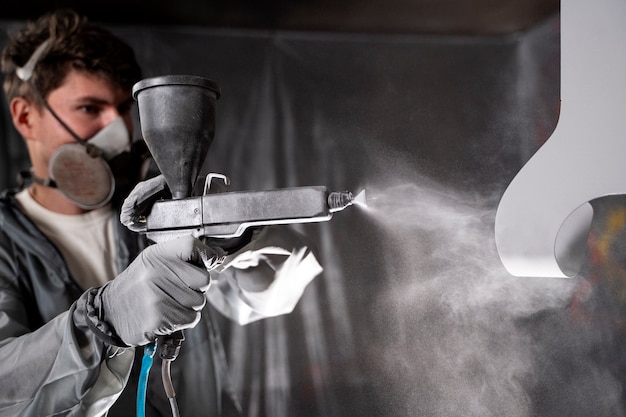 man-working-with-paint-gun-medium-shot_23-2149878805