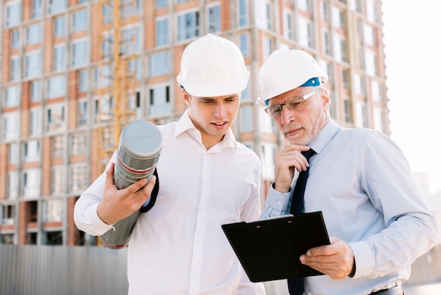 medium-shot-men-with-helmets-clipboard_23-2148269316