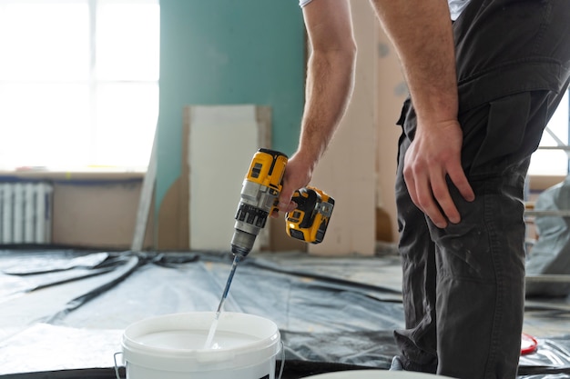 worker-mixing-paing-with-drill_23-2149328042